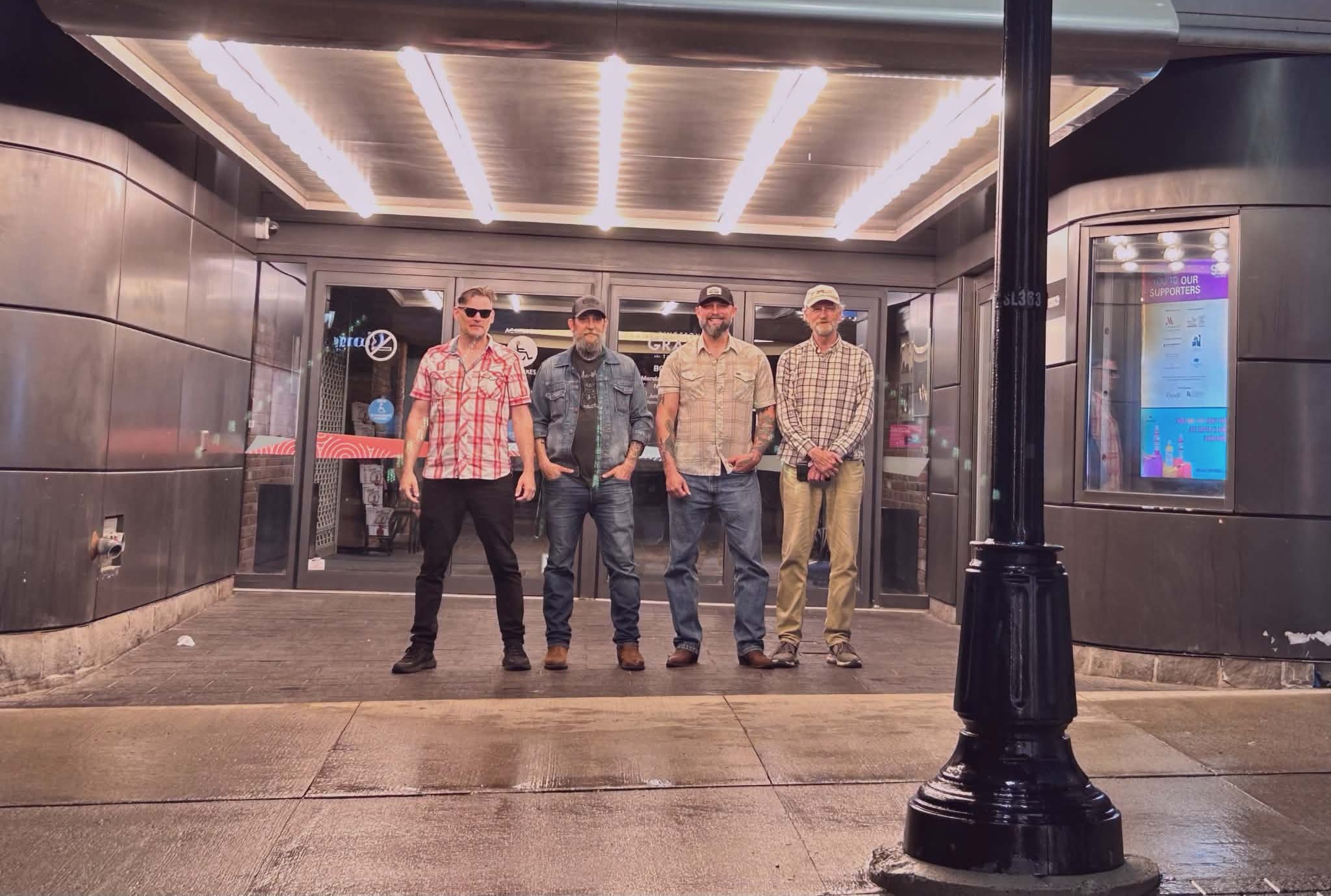 Stompers on the road, under a venue marquee